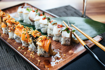 A plate of two sushi rolls with chopsticks