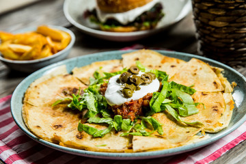 tortilla with tomato sauce, olives and sour cream