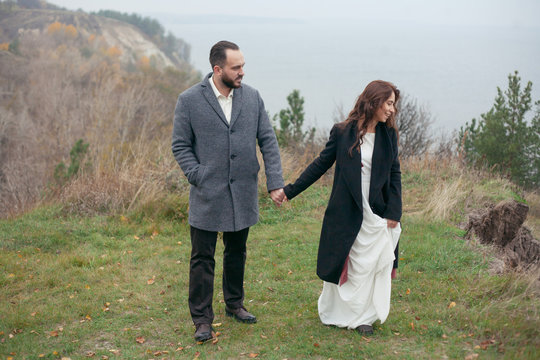 portrait of a wedding couple goes by the hand on the background of nature