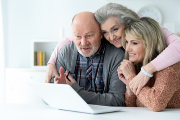 Close up portrait of two smiling senior women and man