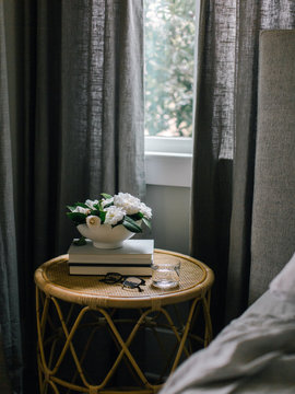 White flowers on table in dark bedroom