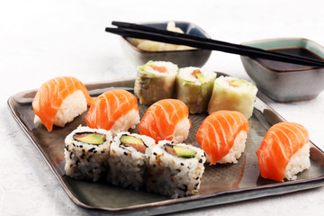 close up of sashimi sushi set with chopsticks and soy - sushi roll with salmon and sushi roll with smoked eel