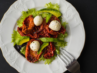 salad made from dried tomatoes, pe-tsai, avocado, and mozzarella cheese. close-up.