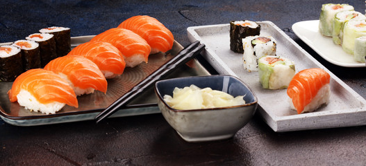 close up of sashimi sushi set with chopsticks and soy - sushi roll with salmon and sushi roll with smoked eel