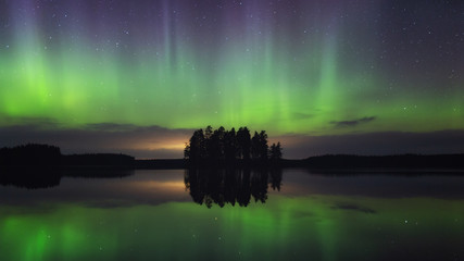 Dancing Northern lights  Aurora borealis  in autumn over beautiful lake and island at night. Finland