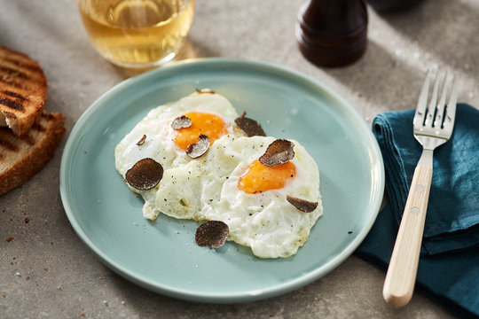 Served fried eggs with slices of black truffle