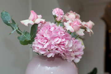 Wedding decorations. Holiday decoration vase with fresh flowers. Pink roses and carnations.