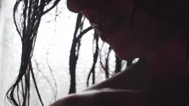 profilo di donna in doccia con capelli bagnati