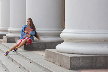 Beautiful girl reading a book near the institute