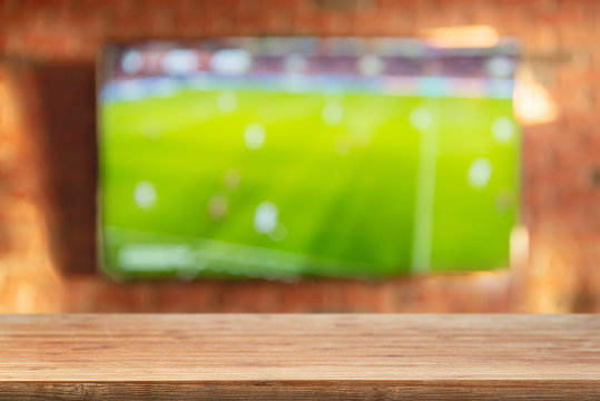 Empty tabletop on brick wall background with tv