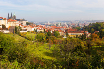 Fototapeta premium Autumn Prague City with gothic Castle and colorful Nature and Trees from the Hill Petrin, Czech Republic