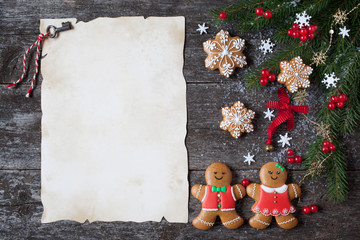 Christmas wooden background with paper for congratulations, fir branches, decor, gingerbread cookies.