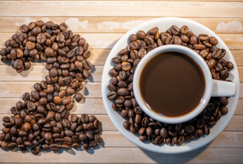 cup of coffee and beans on wooden background