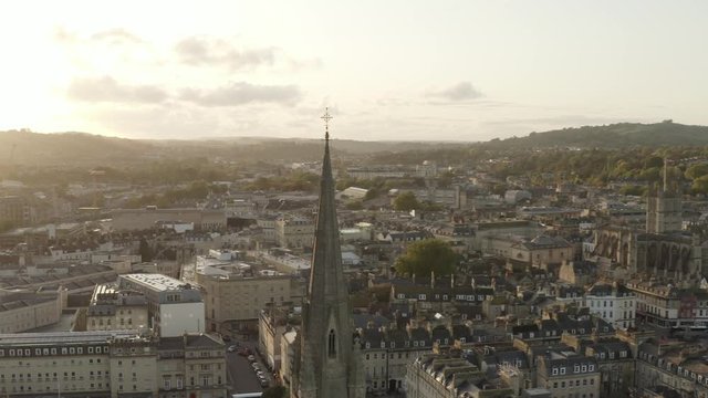 Sun setting over Bath City in England, drone dolly forward then panning right with sun flare
