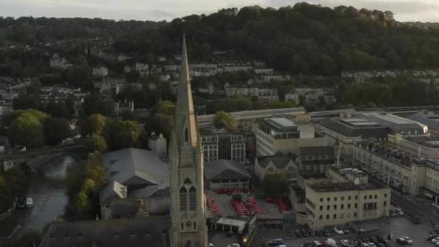 St Johns church, Bath city center, UK. Setting sun and Georgian buildings, drone panning left.