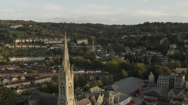 Church spire close up in Bath city center, UK at dusk.  Drone panning left and away.