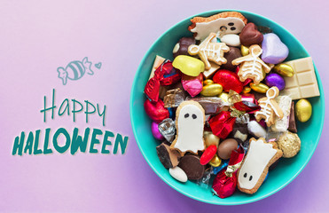 Fototapeta na wymiar Halloween holiday card - candy bowl with candy and halloween cookies Trick or Treat