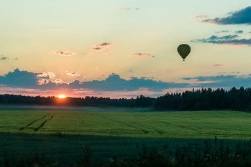 Hot air balloon over sunset evening landscape in Finland