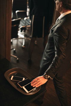 High angle view of male professional keeping smart phone on tray at office