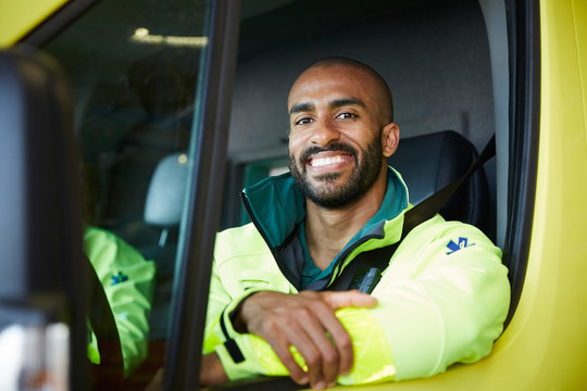 Portrait of smiling male paramedic in ambulance at parking lot