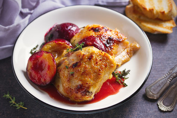 Baked chicken and plums in ginger, honey and red wine sauce with thyme. Horizontal image