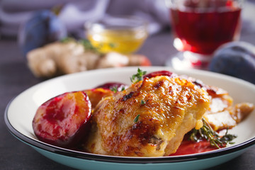 Baked chicken and plums in ginger, honey and red wine sauce with thyme. Horizontal image