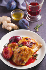 Baked chicken and plums in ginger, honey and red wine sauce with thyme. Vertical image