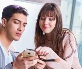 Man doing make-up for cute woman in beauty salon
