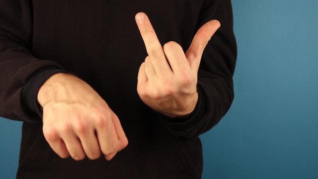 Close up view of a male gesturing with his middle finger, indicating his disrespect and anger