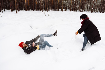 Loving couple have fun in a beautiful winter forest