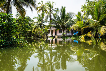 Fototapeta na wymiar House in the Kerala backwaters in the lush jungle along the canal, Alappuzha - Alleppey, India