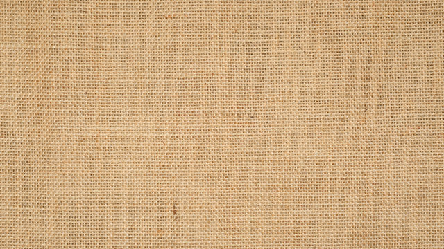 Hessian sackcloth burlap woven texture background  / cotton woven fabric background with flecks of varying colors of beige and brown. with copy space. office desk concept.High Resolution horizontal  