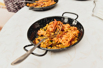 Typical valencian paella in a paella pan as an appetizer, traditional Spanish food.