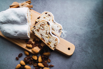 Stollen made with almonds and raisins on a concrete background. German traditional sweet for Christmas.