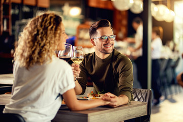 Happy couple in love enjoying in glass of wine during lunch.