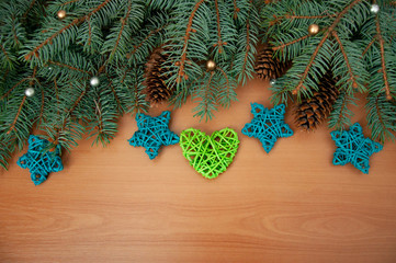 Christmas background. Christmas tree branches, gift, hearts, balls and stars on wooden texture