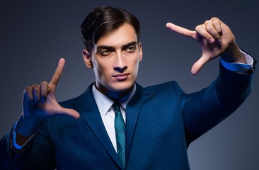 Businessman pressing virtual buttons on gray background