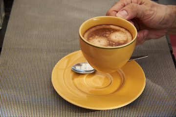 A man hand holding a cup of coffee