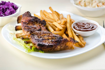 baked ribs and French fries and cabbage salad