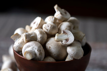 Fresh champignon mushrooms in a bowl. Raw mushrooms. Selective focus. Macro.