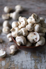 Fresh champignon mushrooms in a bowl. Raw mushrooms. Selective focus. Macro.