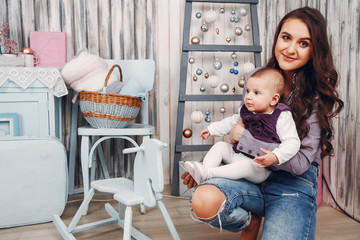 Cute family have fun in decorating room. Beautiful mother with little daughter.