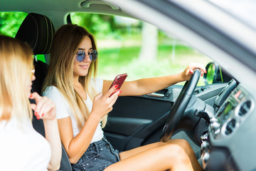 Young woman in the car while the driver using mobile phone and losing concentration.