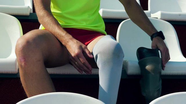 Sportsman is taking off his leg substitute