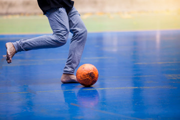 Futsal players wearing sweatpants and barefoot. Futsal player control and shoot ball to goal....