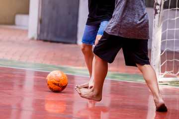 Naklejka premium Futsal players barefoot. Futsal player control and shoot ball to goal. Soccer players fighting each other by kicking the ball. Indoor soccer sports hall. Football futsal player, Orange ball.
