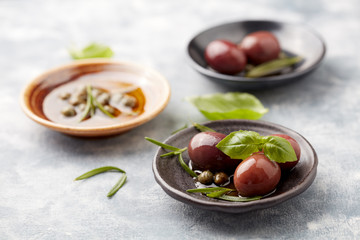 Kalamata olives and capers on bright wooden background. Close up. 