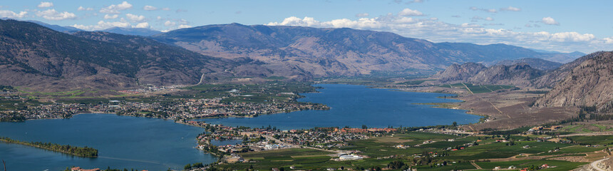 Fototapeta na wymiar Aerial Panoramic View of a Small Touristic Town during a beautiful sunny summer day. Taken in Osoyoos, British Columbia, Canada.