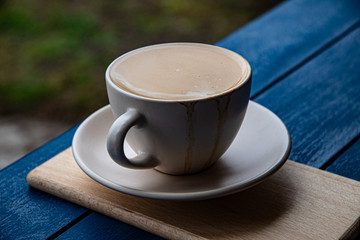 Morning cup of coffee with milk in the park.