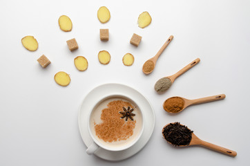 Traditional indian masala chai tea with spices - cinnamon, cardamom, anise, ginger white background. Top view